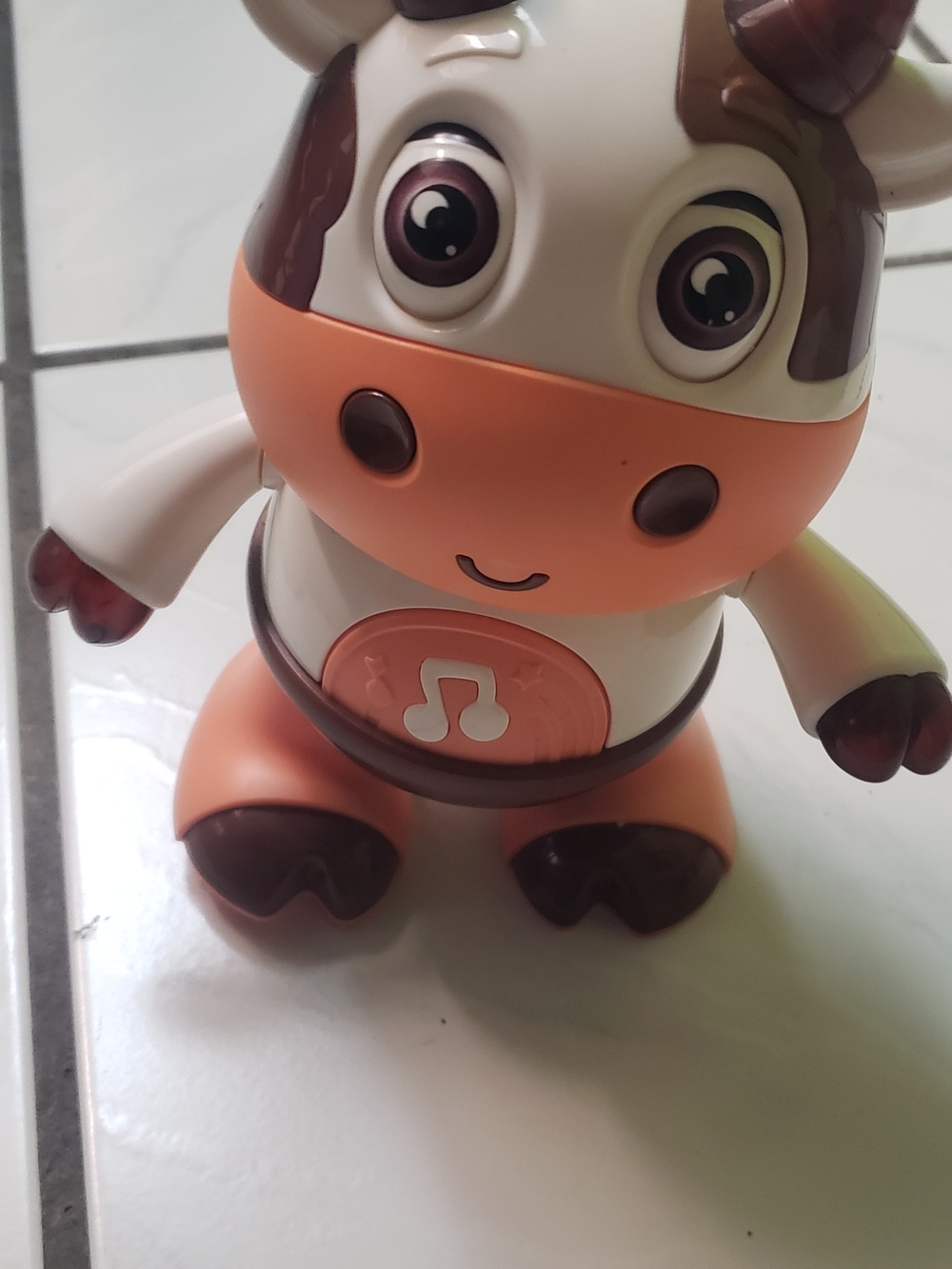 In great condition musical cow plush-style activity toy, peach, brown